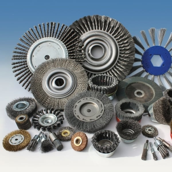 Collection of various wire brushes and grinding wheels in different sizes and materials against a blue background