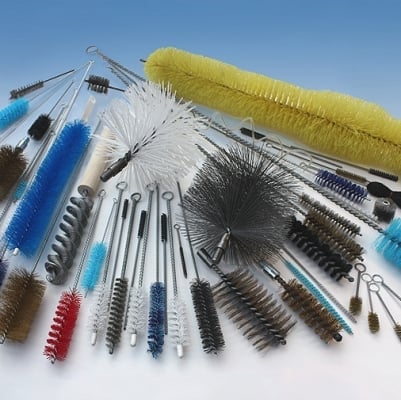 Collection of various industrial cleaning brushes and tubes arranged in a circular pattern on white background