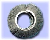 Wire wheel brush with circular bristles and metal center ring on light purple background