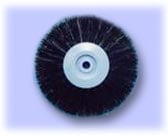 Round brush with black bristles and white plastic center on light blue background