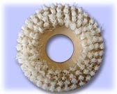 Beige decorative wreath with clustered round beads forming a circular pattern with hollow center on light blue background