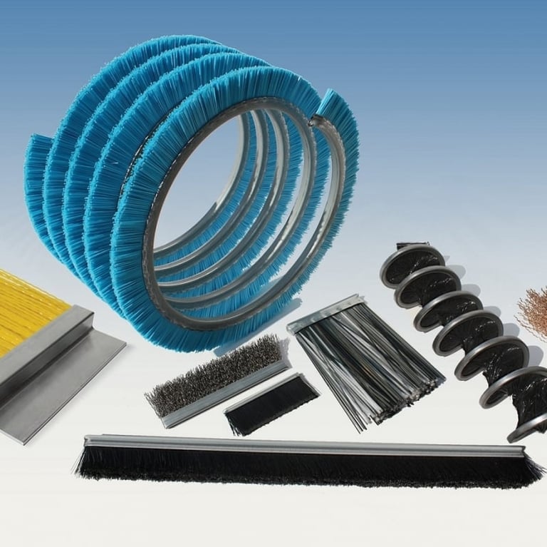 Collection of industrial brushes including blue spiral brush coils, metallic bristle brushes, and black curved brush segments arranged against white background