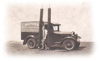 Vintage delivery truck with Hilton signage and two men standing beside it